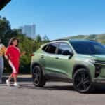 Green 2026 Chevy Trax parked with friends walking toward it.