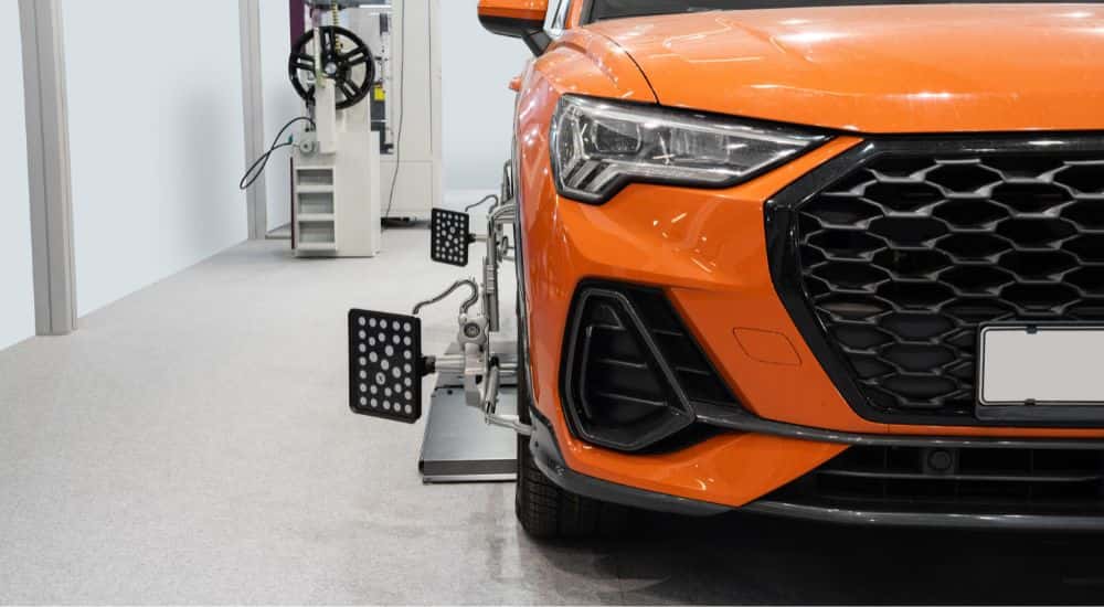 Wheel Alignment from the front end of an orange car.