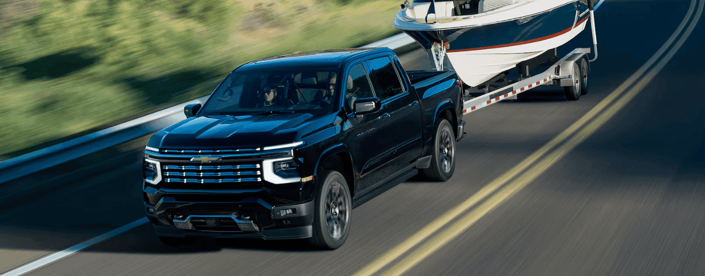 Black 2027 Chevy Silverado 1500 towing a boat