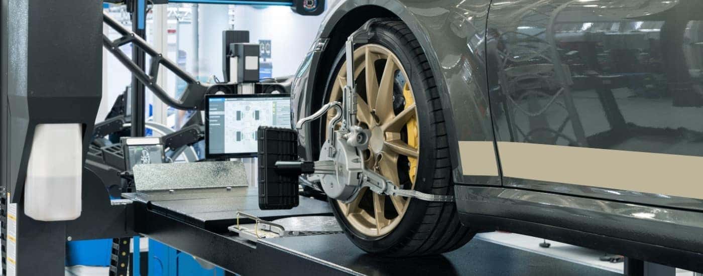 A green vehicle in the process of a wheel alignment.