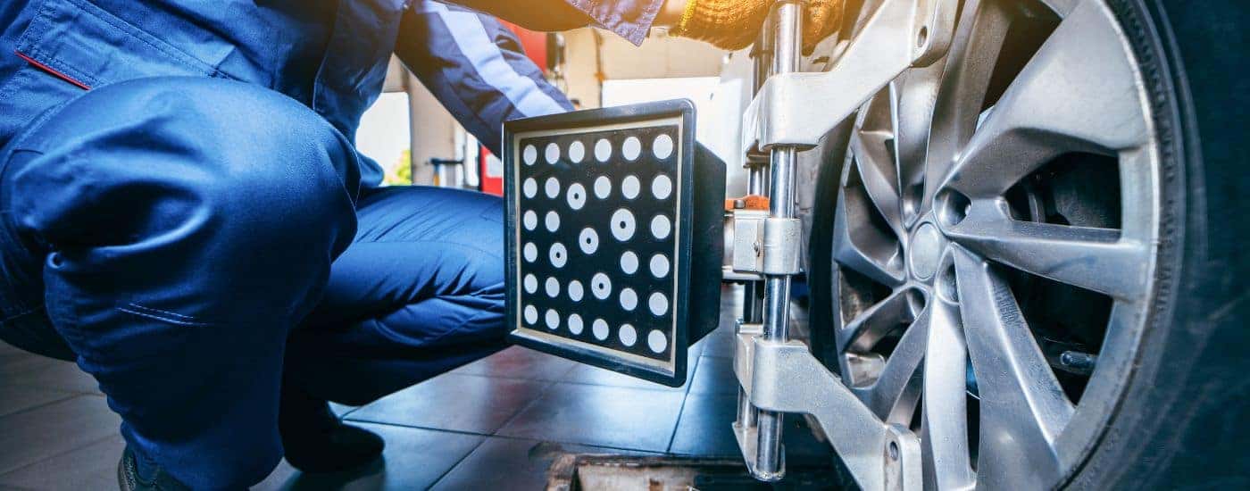 A technician installing the equipment for a wheel alignment.