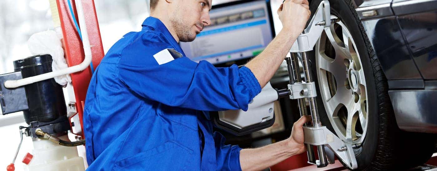 A service technician preparing a vehicle for a wheel alignment.