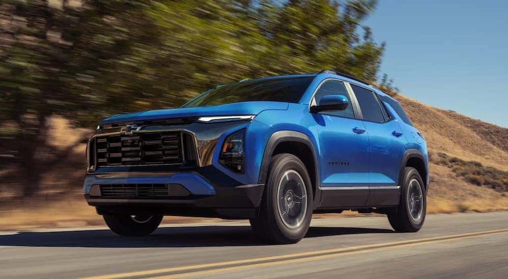 A blue 2027 Chevy Equinox driving on a highway.