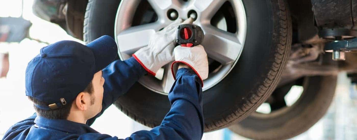 A mechanis tightening bolts on a tire.