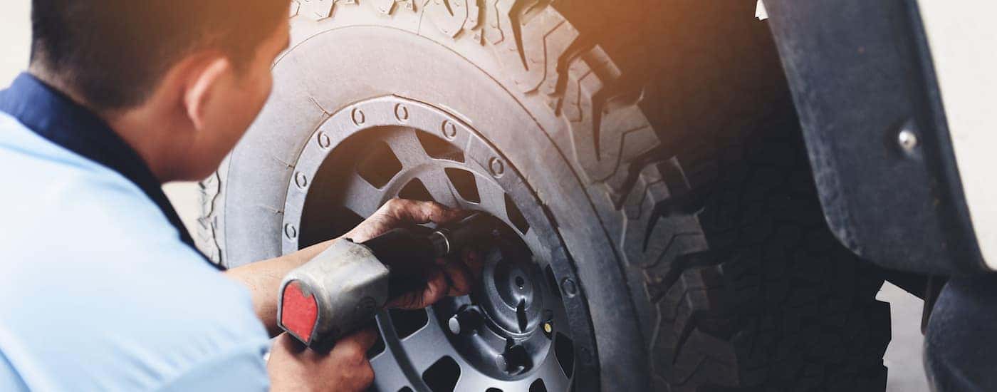 A mechanic tightening a bolt on a tire.