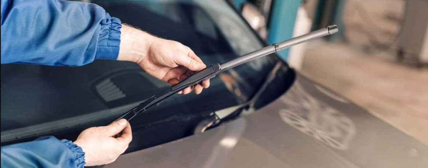 A technician finishing a wiper blade installation.