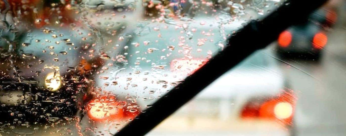 Close-up of a wiper on a wet vehicle windshield.