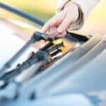 A person adjusting a windshield wiper blade.