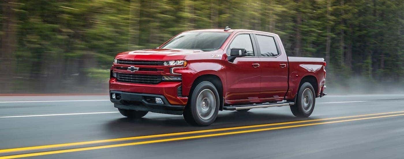 A red 2021 Chevy Silverado 1500 Z71 driving on a wet road