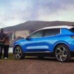 A couple standing by a blue 2027 Chevy Equinox EV LT 2.