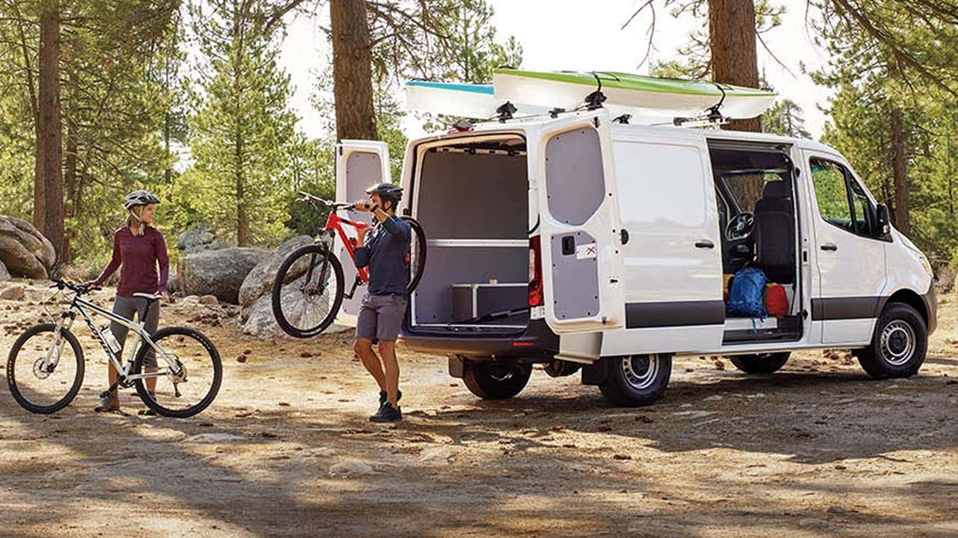 family taking bikes out of 2025 white sprinter van