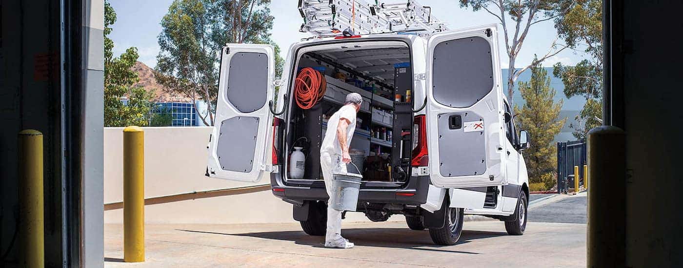 Person opening the back of a white 2026 Mercedes-Benz Sprinter Van.