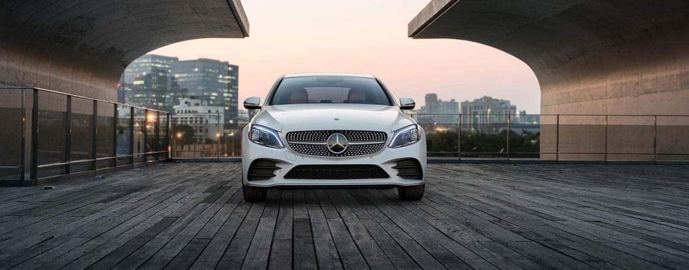 Front of a white 2020 Mercedes-Benz C-Class parked on a boardwalk.