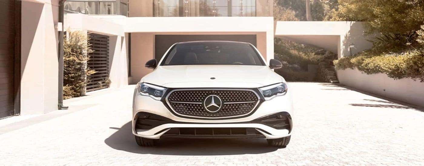 Front of a white 2024 Mercedes-Benz E-Class parked in a driveway.