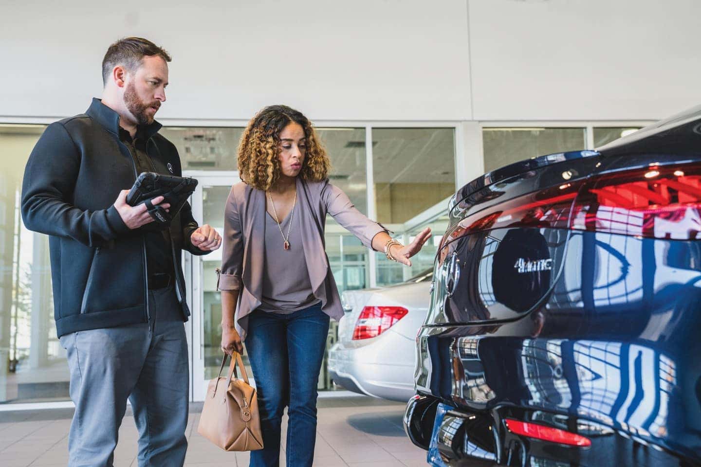 Service advisor reviewing tiered You Spend You Save savings with a customer at Mercedes-Benz of Midlothian