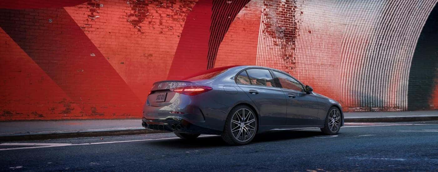 Grey 2025 Mercedes-Benz AMG parked near a red wall