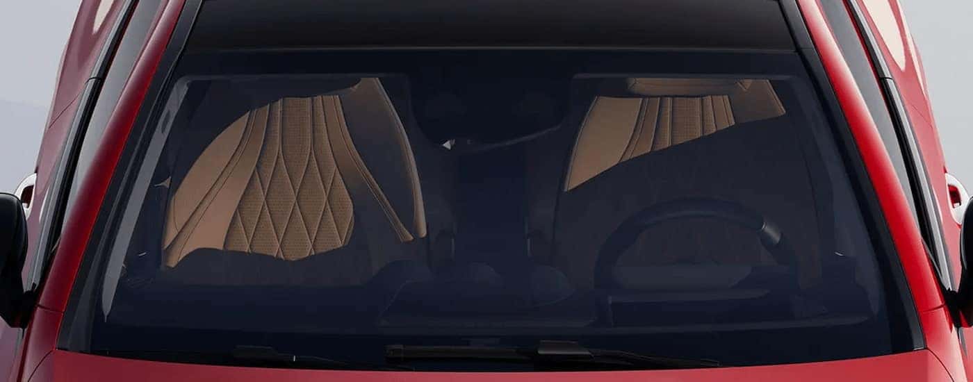 Front seats through the window of a red 2026 Mercedes-Benz CLE