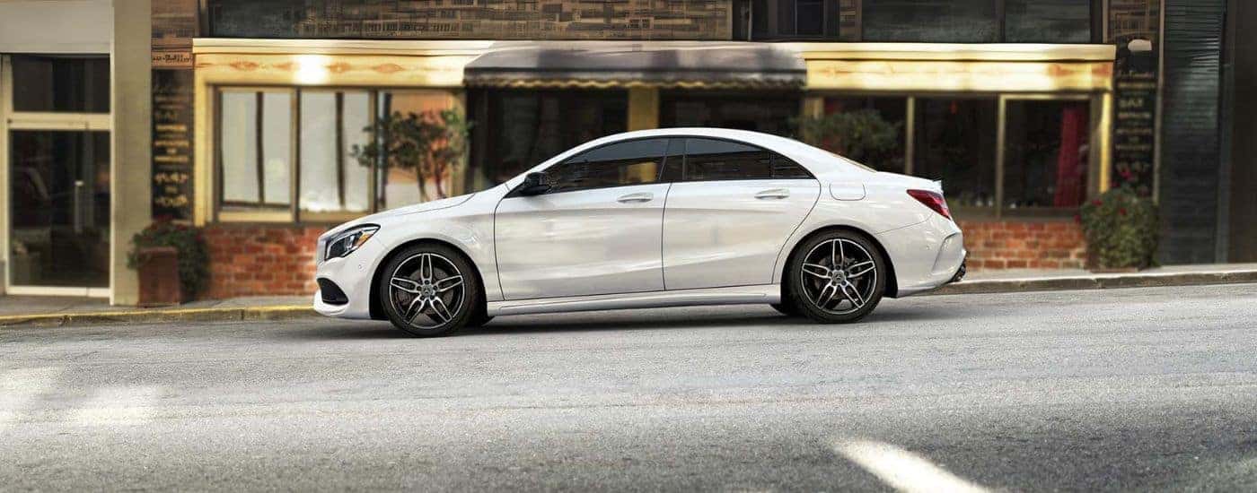 Side of a white 2019 Mercedes-Benz CLA parked near a curb.