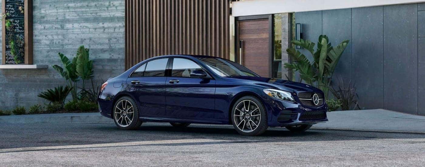 Side of a blue 2020 Mercedes-Benz C-Class parked outside a building.