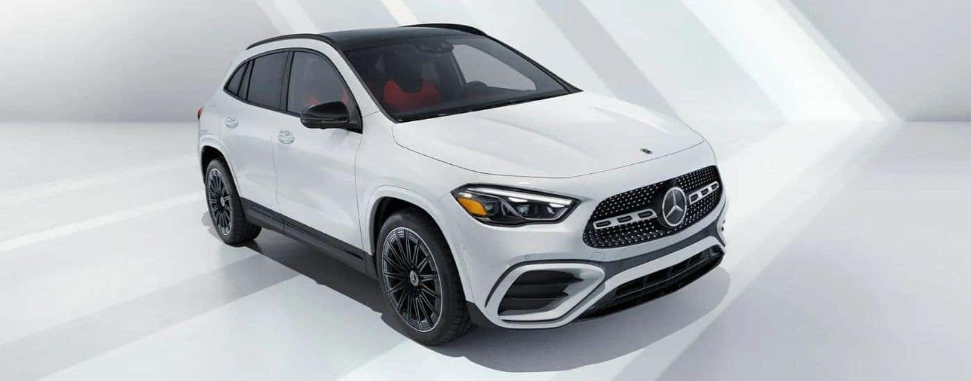 White 2026 Mercedes-Benz GLA SUV parked against well lit white wall