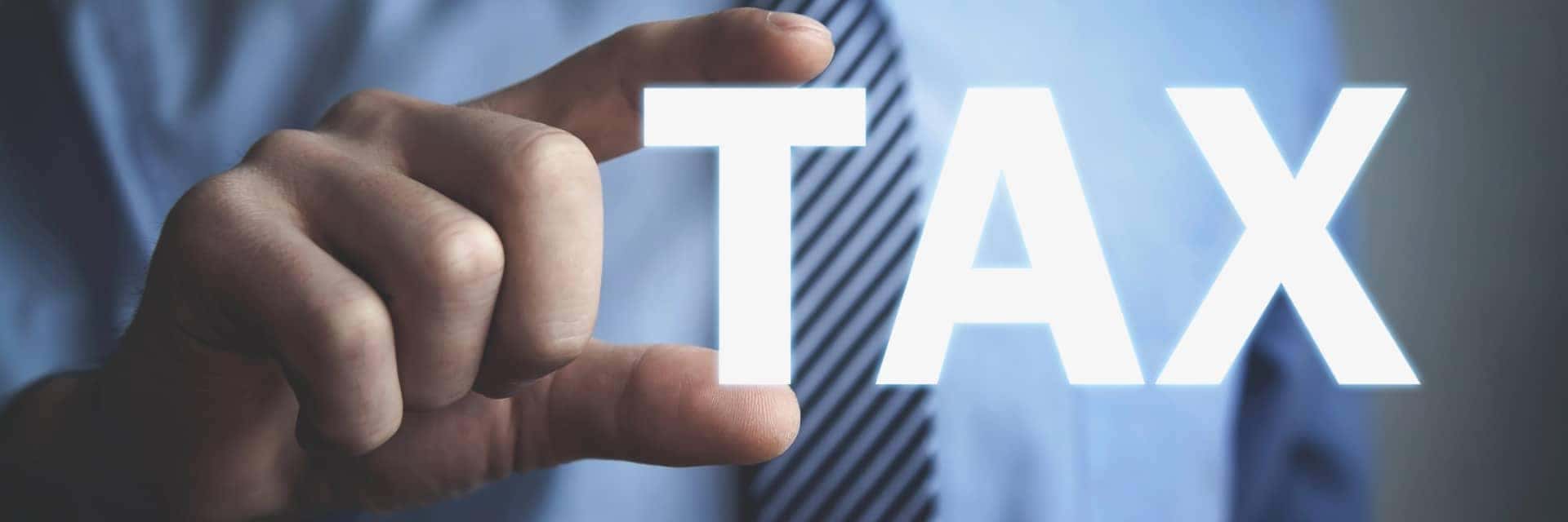 business man holding the word TAX