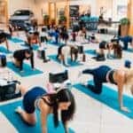 Women attending a mat Pilates class inside the Mercedes-Benz of Sugar Land showroom during the Driven by Wellness event