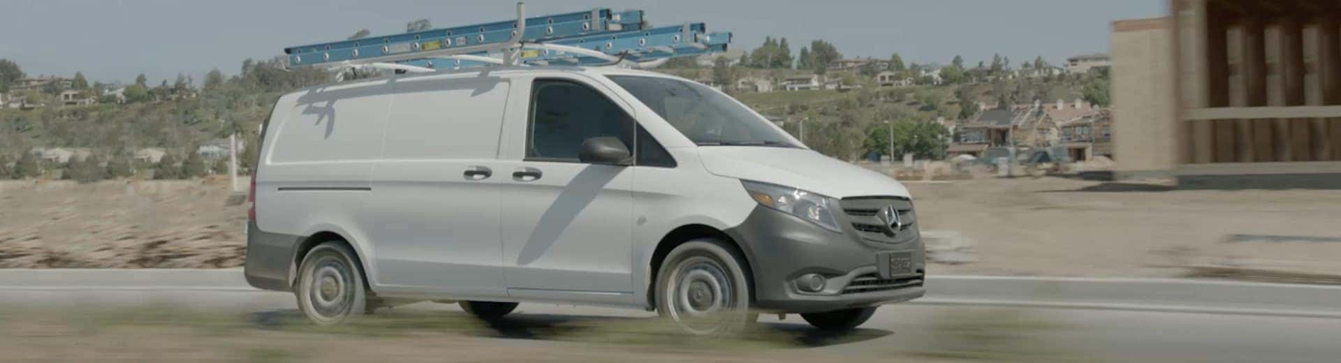 White Metris van driving down a road