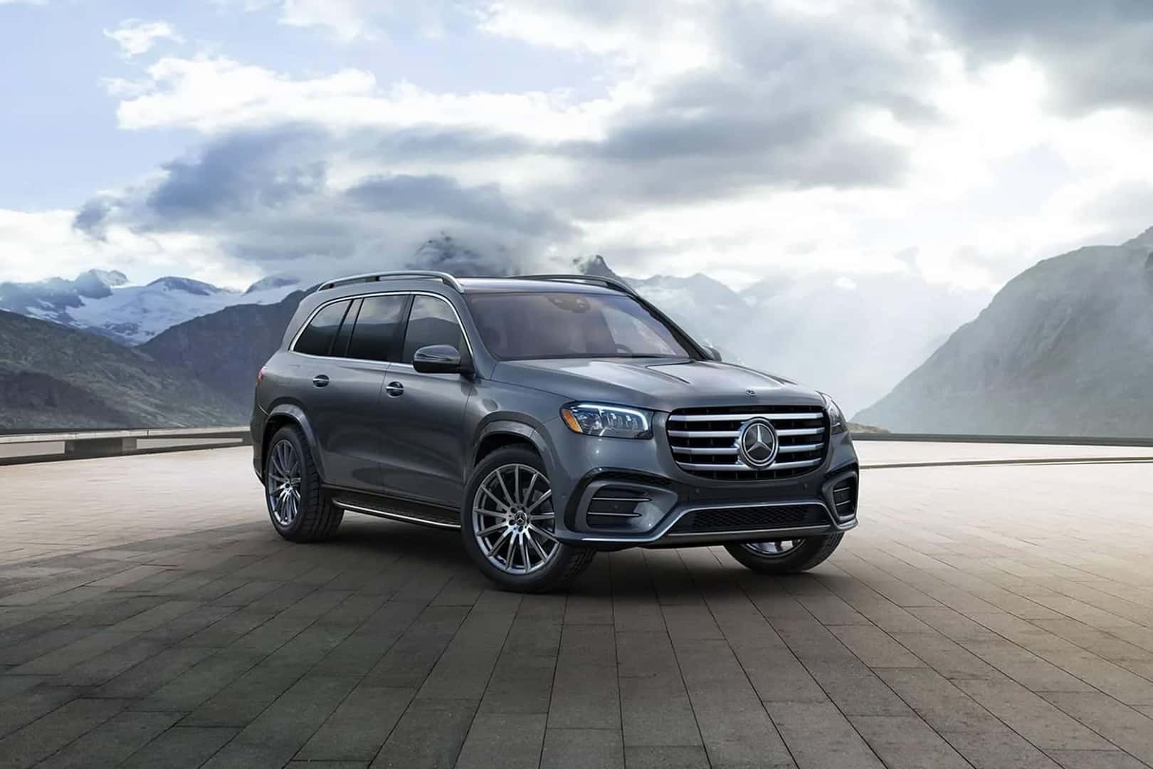 gls suv parked in front of clouds and mountain