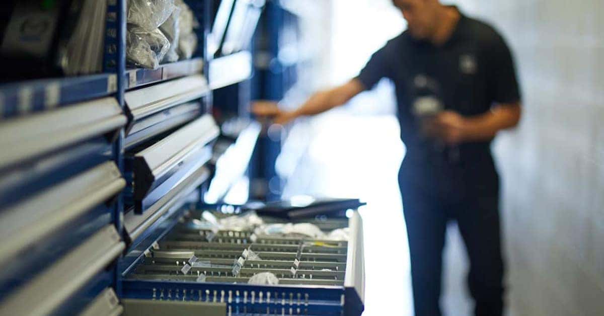 Mazda service technician searching for parts in drawers
