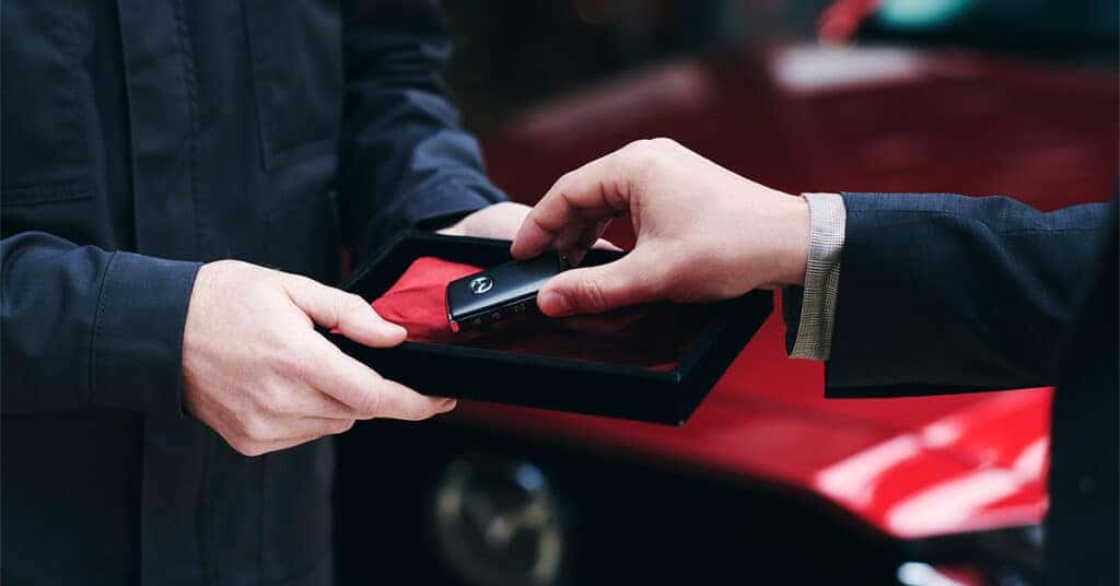 hand taking Mazda key fob out of a box