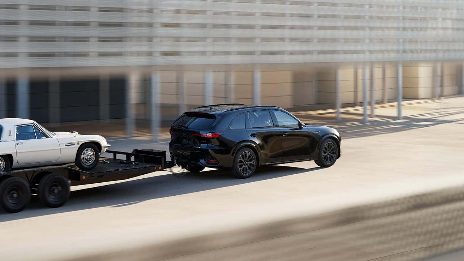 2026 Mazda CX-70 towing a trailer with a sports car