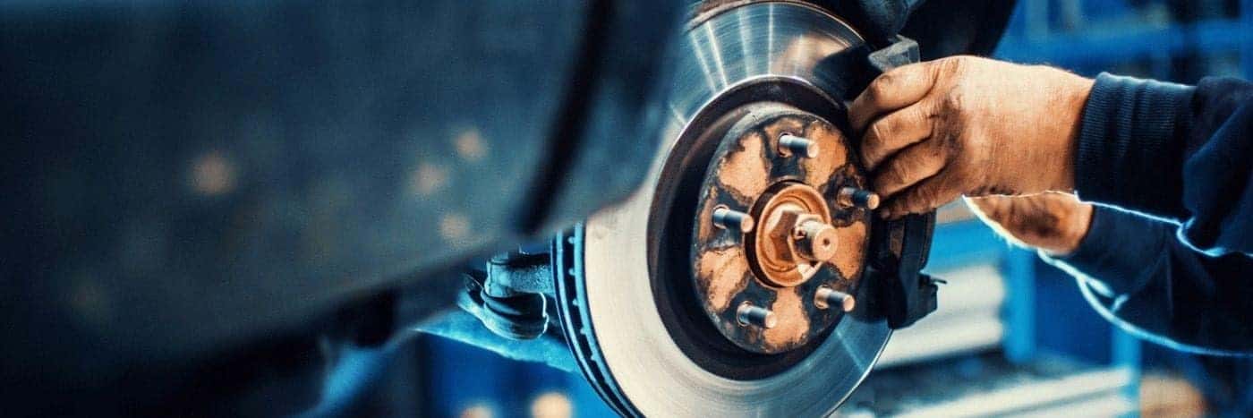Close up view of a service tech inspecting a brake rotor
