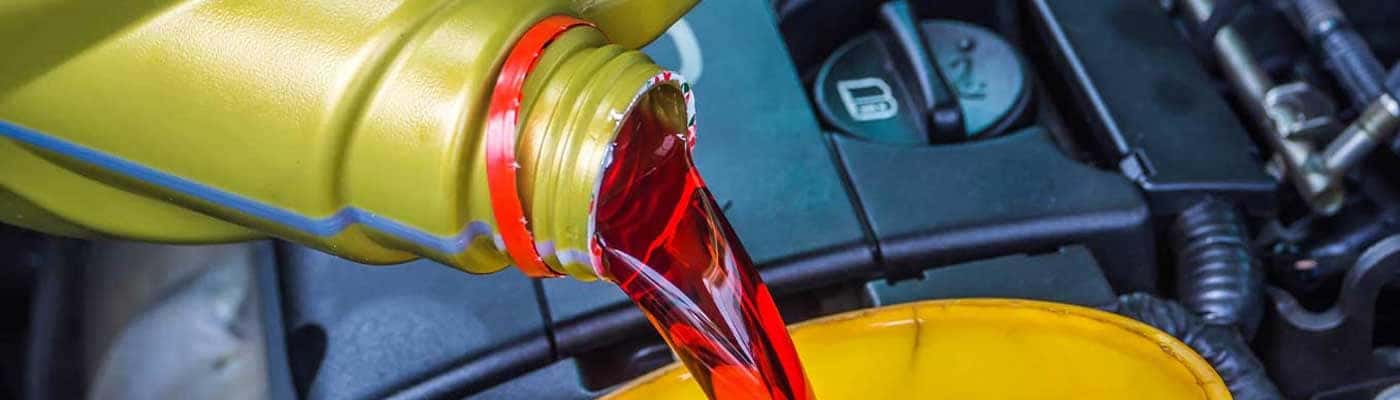 close up view of transmission fluid being poured from a bottle