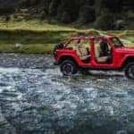 Red Jeep Wrangler With Doors Removed Next to River