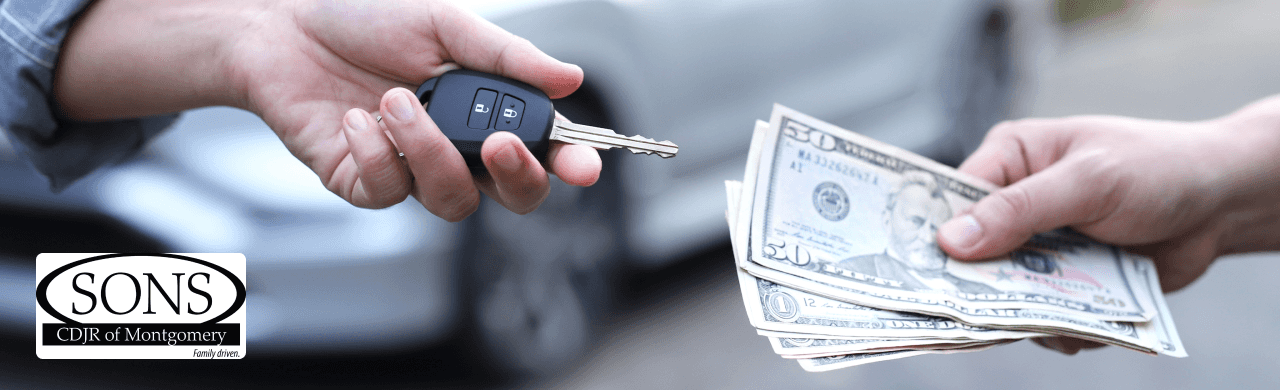 A customer happily traded in their car at SONS CDJR of Montgomery with a dealership representative assisting.