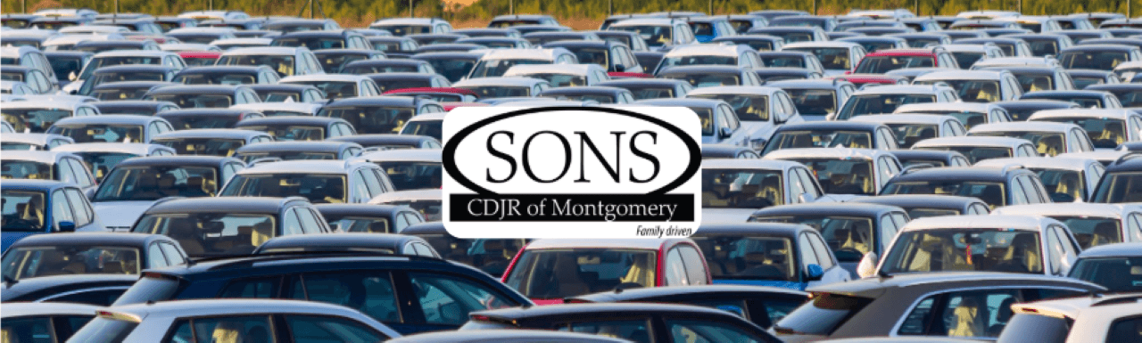 A large, modern SONS CDJR dealership with multiple cars parked on the clean lot.