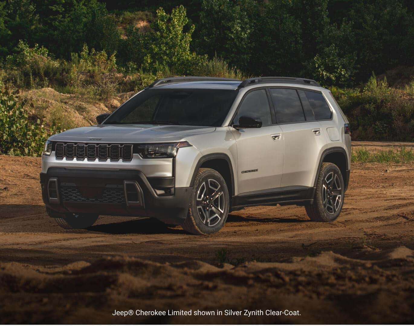 Front three-quarter view of a 2026 Jeep Cherokee Limited in Silver Zynith Clear-Coat parked on a dirt path.
