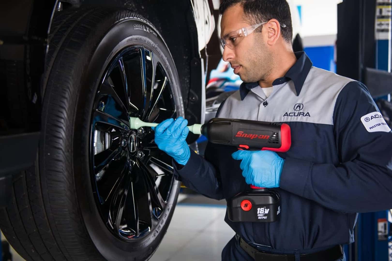 acura service technician working on tire