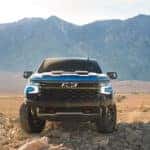 blue 2024 chevy silverado 1500 parked in the desert with mountains in the background