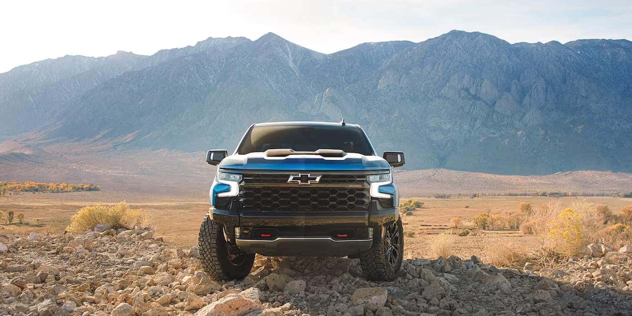 blue 2024 chevy silverado 1500 parked in the desert with mountains in the background