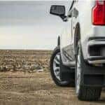 2024 Chevy Silverado 1500 in white paint photographed from behind showing its taillight and rear profile.