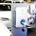 White electric vehicles in a row at charging stations