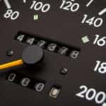 Closeup of analog speedometer with odometer in the middle