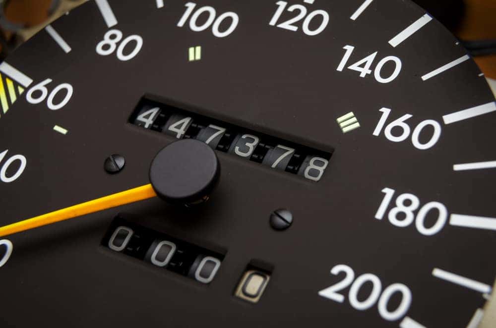 Closeup of analog speedometer with odometer in the middle