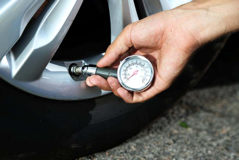 Man Checking Air Pressure on Tires