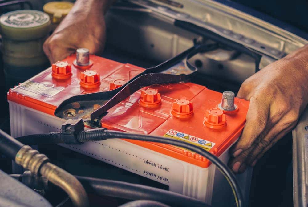 Man's Hands Pulling Out a Car Battery