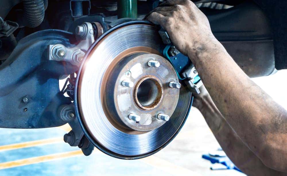 Man's Hands on Disc Brakes on a Car
