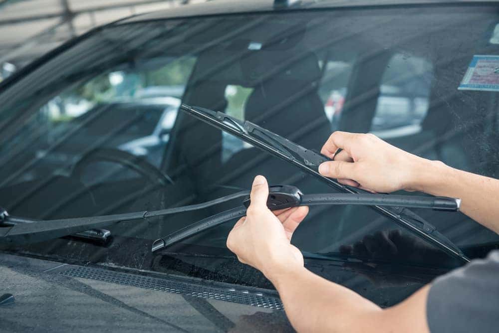 Man's hands replacing a windshield wiper blade