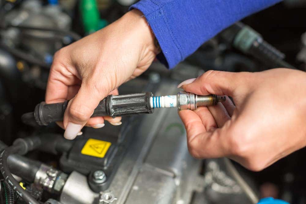 Man's hands changing a sparkplug