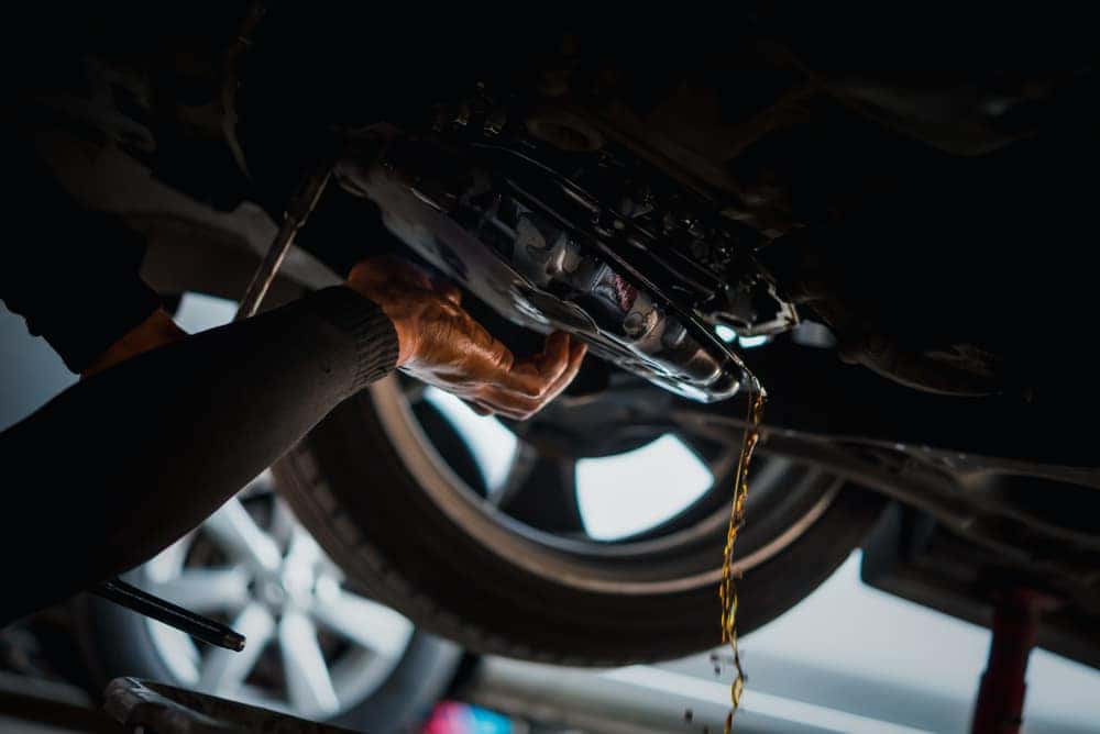 Man draining oil from a vehicle